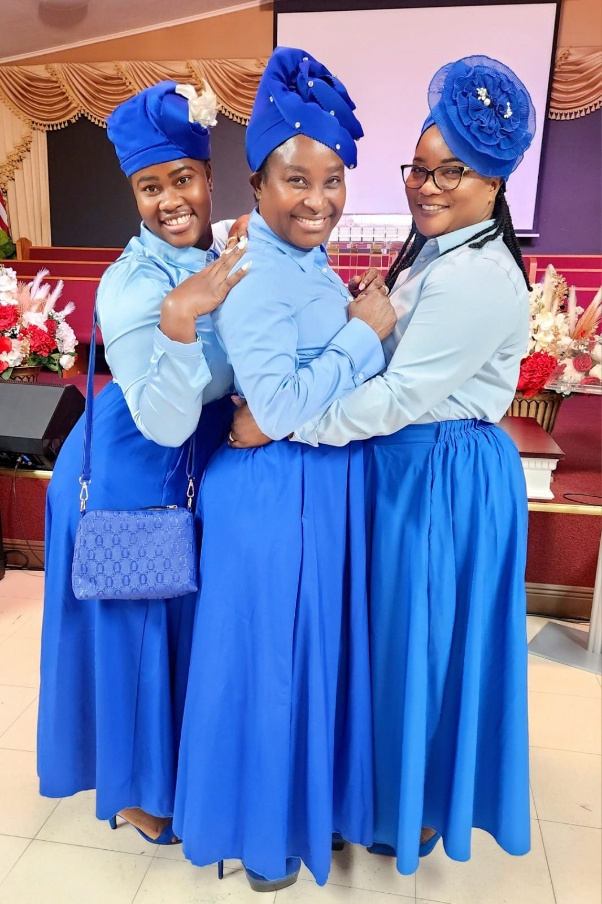 Friendly Haitian church greeter holding the door open with a smile